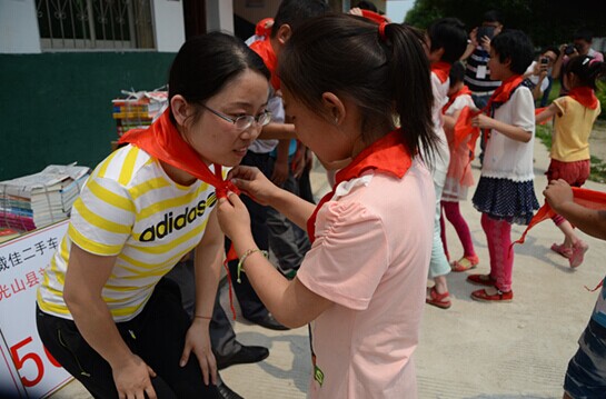 捐贈儀式上，孩子們?yōu)閻坌奶焓瓜瞪霞t領巾