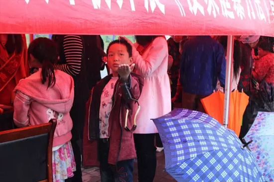 因?yàn)橛晗碌奶?，小男孩玩起了接水游戲? complete=