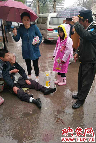 女孩為倒地老人撐傘。