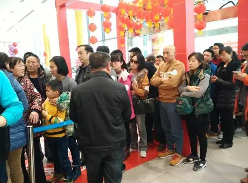 排隊領(lǐng)年貨，一家老小齊上陣。