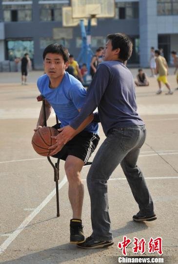 圖為拄著拐杖的瞿詩濤和同學(xué)搶球。劉占昆攝