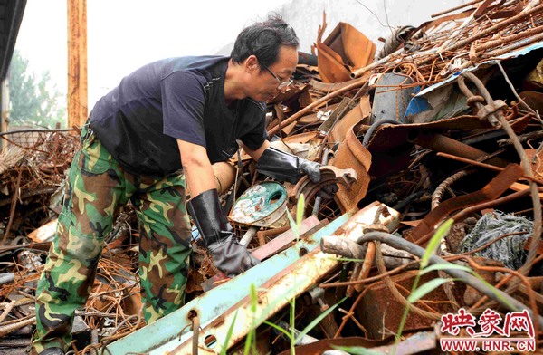 劉金玉正在從廢料堆里挑揀能用的廢料