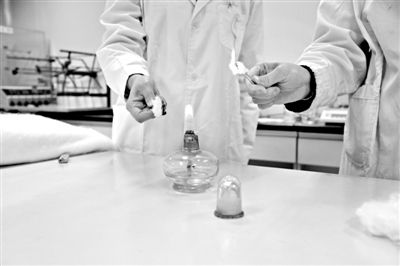 實(shí)驗(yàn)人員操作的燃燒檢測法中，真蠶絲離開火焰就熄滅(左)。