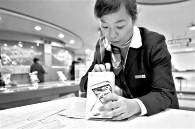 11月6日，北京移動西直門營業(yè)廳的工作人員在為顧客購買的4G手機登記。新華社發(fā)