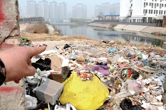 金水河長江路橋下河水發(fā)臭，水邊堆放眾多垃圾