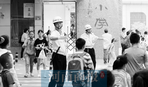 伊河路小學(xué)門口，兩名巡防隊(duì)員護(hù)送學(xué)生過馬路