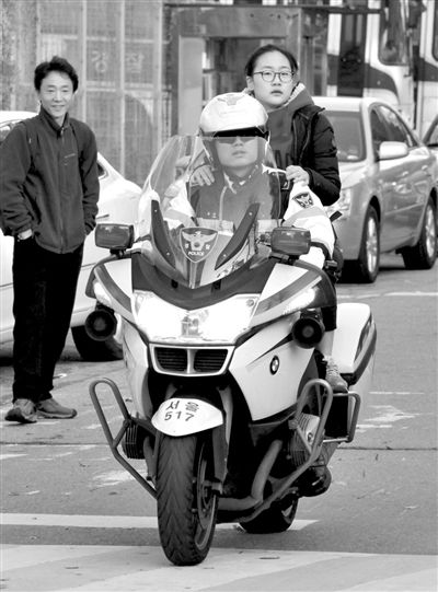 7日，首爾，警察將一名考生送抵考場(chǎng)。新華社發(fā)