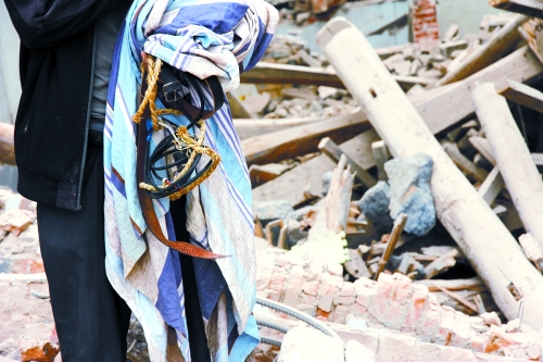 老人手中拿著曾控制住他的電線、床單