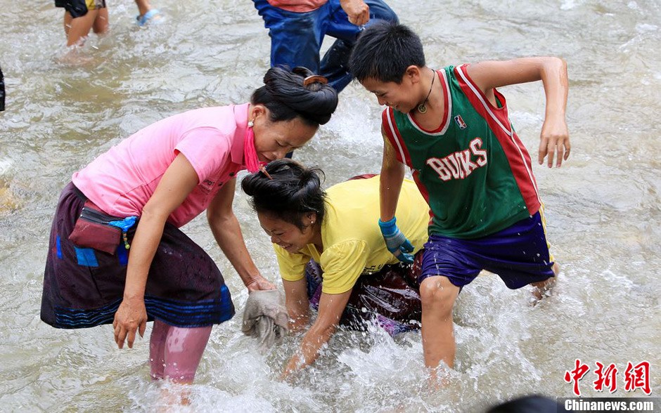 7月9日，村民在小河里摸魚搶魚。譚凱興 攝