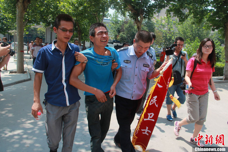 圖為獲救嬰兒父親情緒一度失控，當?shù)鼐焦ぷ魅藛T對其進行攙扶。張一辰 攝