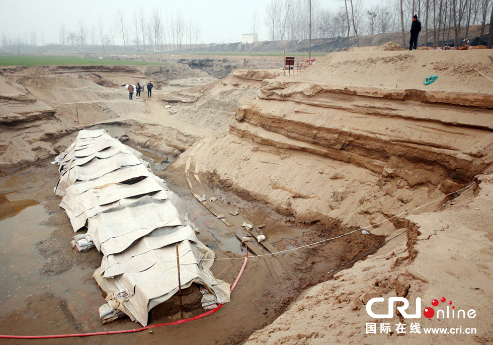 2014年1月6日，河南洛陽古沉船發(fā)掘現(xiàn)場，近日有雨雪天，考古人員給古沉船披上一層“雨衣”。