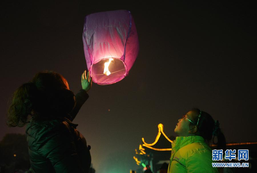 　1月30日，游客在江蘇省鎮(zhèn)江市金山公園門(mén)口放飛孔明燈。