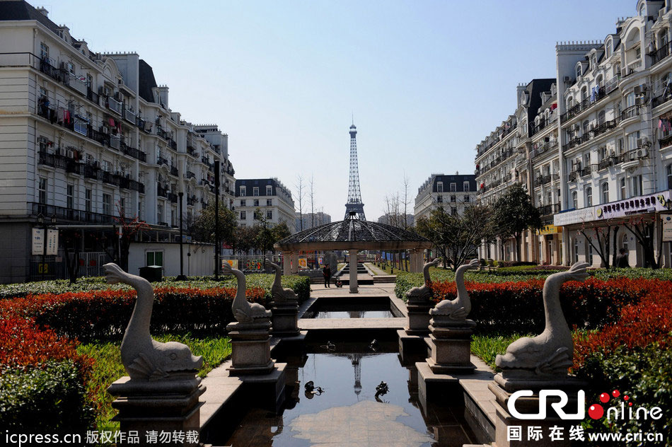 　2014年3月21日，杭州天都城，農(nóng)民在山寨埃菲爾鐵塔下耕作。圖片來(lái)源：東方IC