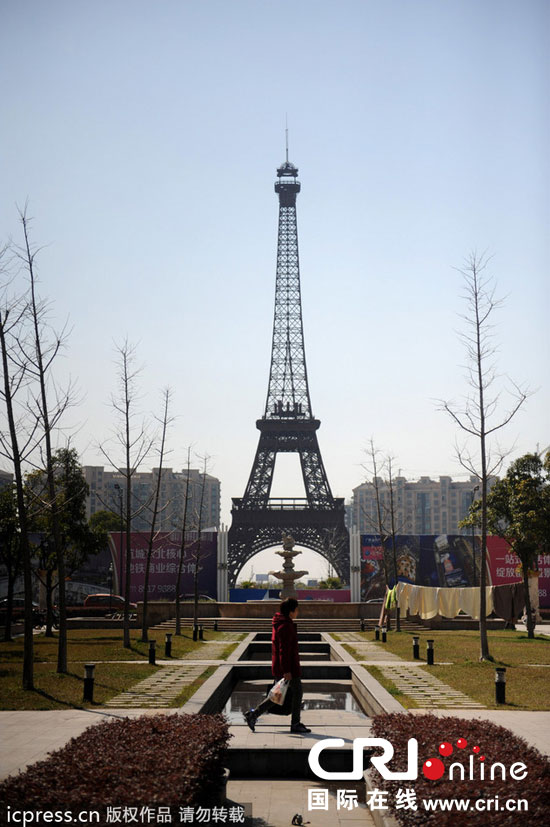 　2014年3月21日，杭州天都城，農(nóng)民在山寨埃菲爾鐵塔下耕作。圖片來(lái)源：東方IC