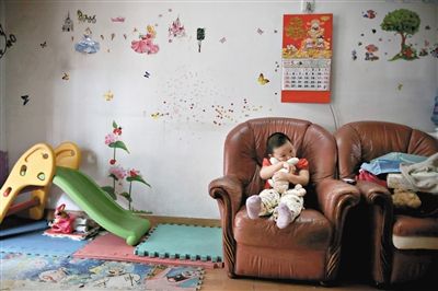 6月14日，未婚媽媽于軍的家里。女兒悅悅抱著兔子玩偶，在聽媽媽手機(jī)上的兒歌，這個(gè)4歲女孩喜歡兔子。