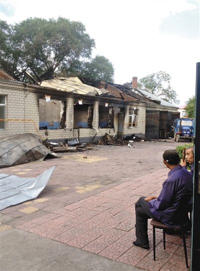 7月27日，海倫聯(lián)合敬老院內(nèi)，幾名老人看著對面被燒毀的特護病房。新京報記者 涂重航 攝