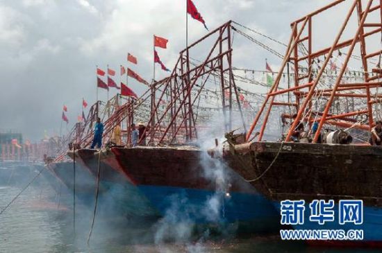 2013年8月1日 南海開漁日 臨高迎新港 8月1日，海南省臨高縣漁民在船上鳴放鞭炮慶祝武蓮港開港。
