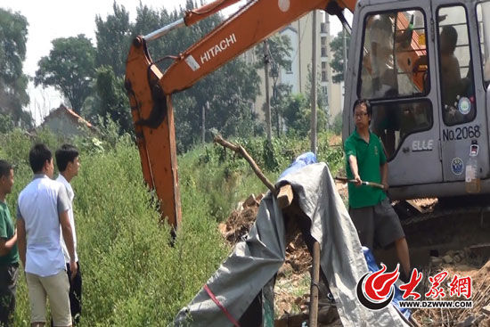 陳寶成手持自制刀斧守在挖掘機旁阻止便衣民警靠前。駕駛室內(nèi)，張朋珂正向受害人郭曉剛身上澆汽油。（視頻截圖）