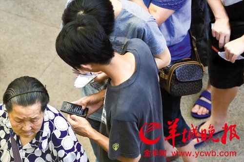 排隊的“黃?！备魇謭?zhí)一疊白紙，上面寫好了要掛號的人的信息，包括姓名、電話、要掛的科室等。穿黑白花紋衣服的老婆婆正在排隊掛號