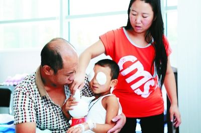 斌斌手術(shù)后第一天恢復(fù)良好，斌斌父母在用玩具逗他開心供圖/嚴益