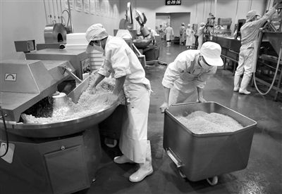 昨日，位于順義李遂開發(fā)區(qū)的慶豐包子鋪配送中心生產(chǎn)車間，工人們正在斬拌胡蘿卜餡料。