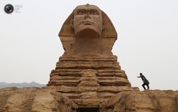 石家莊郊外，一名男子與山寨版獅身人面像合影留念。