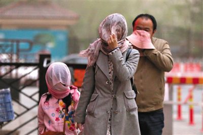 昨日下午，朝陽(yáng)區(qū)豆各莊，行人將紗巾裹在頭上防沙塵。