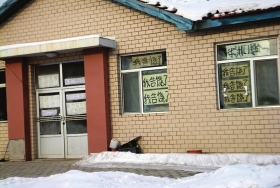 伊春市帶嶺區(qū)一排破舊的平房，房間窗戶上貼滿了“我告饒了”的字樣。