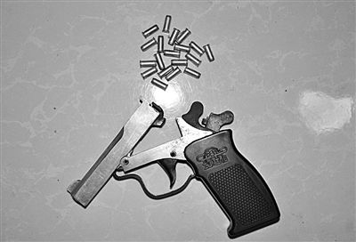 警方從搶劫嫌疑人處起獲的贓款和發(fā)令槍、子彈。警方供圖