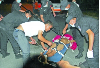 眾人合力將狂犬病發(fā)作的江某控制住。 孫東城 攝