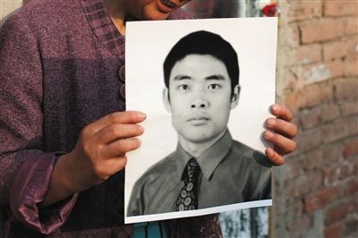 5月19日，朝陽北路，母親捧著張東文的遺像。新京報記者 侯少卿 攝