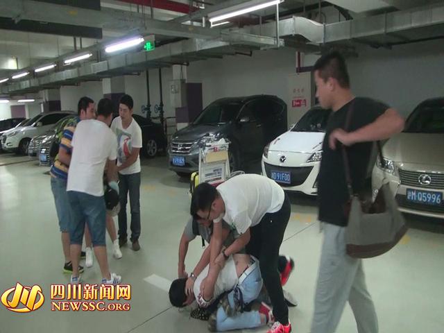 辦案人員在機(jī)場(chǎng)停車場(chǎng)抓獲胡某及其女友（警方視頻截圖）。