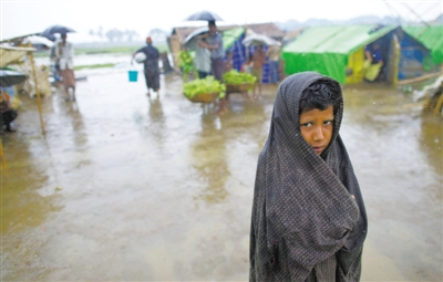 5月14日，緬甸若開邦實兌難民營，羅興亞族難民在雨中行走。熱帶風暴“馬哈森”即將登陸緬甸，這里的難民開始乘船撤離。