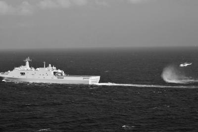 11日，抵達馬航飛機失聯(lián)海區(qū)的海軍井岡山艦與艦載直升機協(xié)同展開立體搜救行動。新華社發(fā)