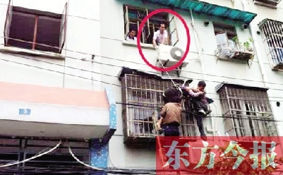 施救現(xiàn)場，劉鵬（圈內(nèi)）先用繩子捆住老太確保安全 勞動報記者 郭娜 供圖