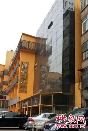 該酒店為加蓋樓層統(tǒng)一安裝上黑色玻璃，從前面看不出加蓋的痕跡