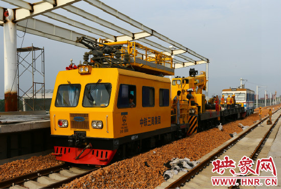 一列工程車從站臺(tái)駛過。