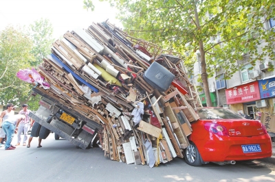 紅色小轎車(chē)被砸，卡在路邊動(dòng)彈不得。
