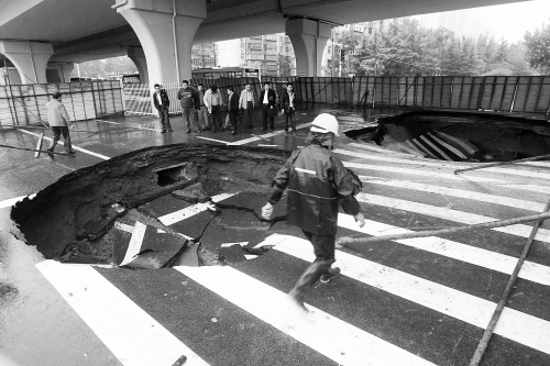 中原路西三環(huán)立交橋下由南向北原本4個(gè)車道，由于塌坑，而今3個(gè)車道被圍擋