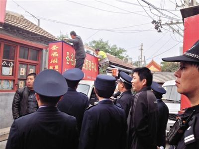 昨日下午,東城區(qū)工商、城管、公安等部門(mén),對(duì)雍和宮附近的預(yù)測(cè)中心進(jìn)行清理整頓,站在車(chē)頂?shù)膬擅と苏鸪患摇邦A(yù)測(cè)中心”的招牌。因雍和宮、白云觀等文化景點(diǎn)外聚集大量算命先生,被媒體稱(chēng)為“算命一條街”。本版攝影/新京報(bào)記者 李寧 攝