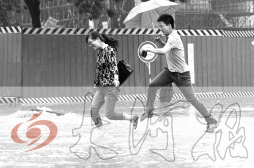 鄭州經(jīng)三路與北環(huán)交叉口處，積水較深，行人們不得不“練輕功”。 記者 白周峰 攝影