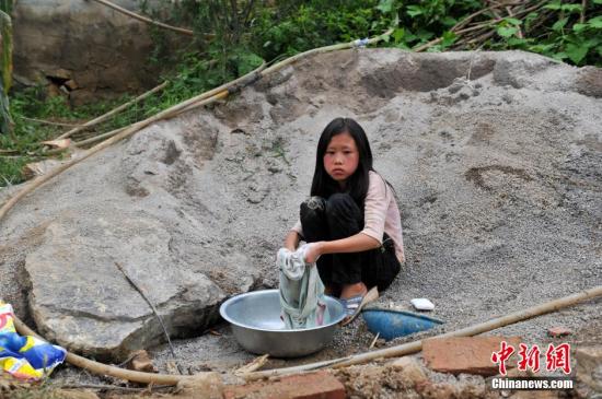 8月9日，云南巧家紅石巖村，10歲的劉鑫蕊在洗自己的衣服