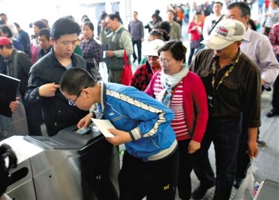 去年5月5日，14號(hào)線園博園站，乘客刷卡出地鐵。北京公交地鐵將實(shí)行計(jì)程票制，多乘坐多付費(fèi)。