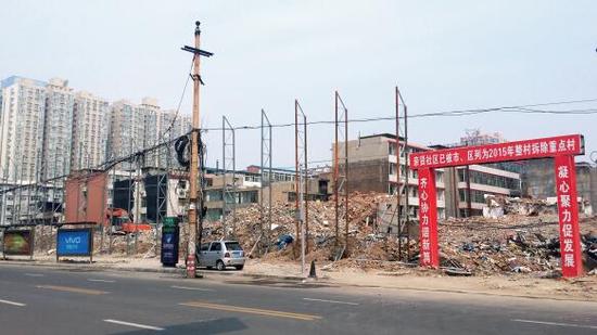 015年5月31日，在社區(qū)干部的帶頭拆遷下，親賢社區(qū)的“城中村改造”拉開帷幕。由于前期“清產(chǎn)核資”及補(bǔ)償標(biāo)準(zhǔn)等因素，拆遷改造工作推進(jìn)并不順利。圖為位于體育西路東側(cè)集體所有的商鋪率先被拆遷完畢，用于遮擋的圍擋正在施工中。（拍攝：2015年9月16日）