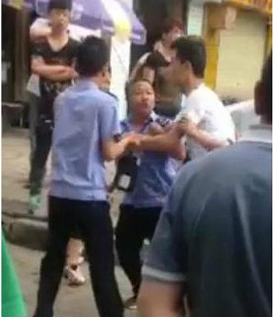 付某（右）與城管執(zhí)法人員廝打在一起。