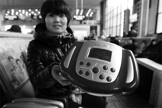 火車站候車室，李女士向記者展示她準(zhǔn)備孝敬父母的按摩儀