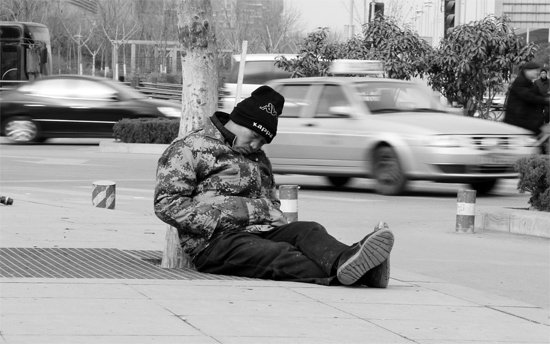 2月2日，鄭州市中州大道農(nóng)業(yè)路立交橋下，50歲的王文德打算在臨近春節(jié)前再接些零活兒，由于疲憊，他睡著