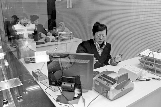 2月16日，鄭州市自來水總公司鄭東新區(qū)一營業(yè)廳，柜臺內(nèi)工作人員正在為市民辦理業(yè)務(wù)