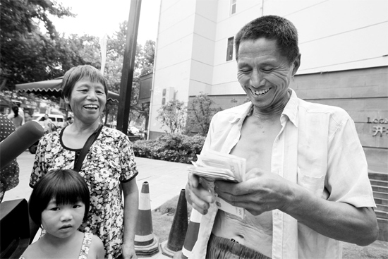 昨日，鄭州市明達(dá)路與豐慶路交叉口西300米路南，來自中牟的瓜農(nóng)拿到西瓜款，笑開顏東方今報(bào)記者袁曉強(qiáng)