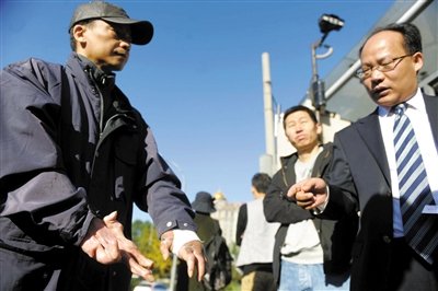 常林鋒在法院外展示雙手，他稱(chēng)被燙傷的手因刑訊逼供且未得到及時(shí)救治